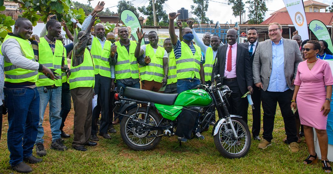 Zembo riders and the Yongeza and Zembo teams with a green Zembo electric motorcycle