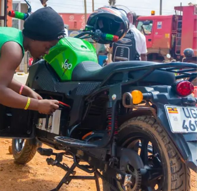 A Yongeza rider servicing her electric motorcycle at a swap station in Uganda